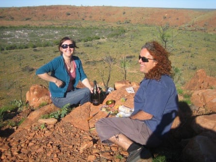 The couple eat and drink on the rim of a crater