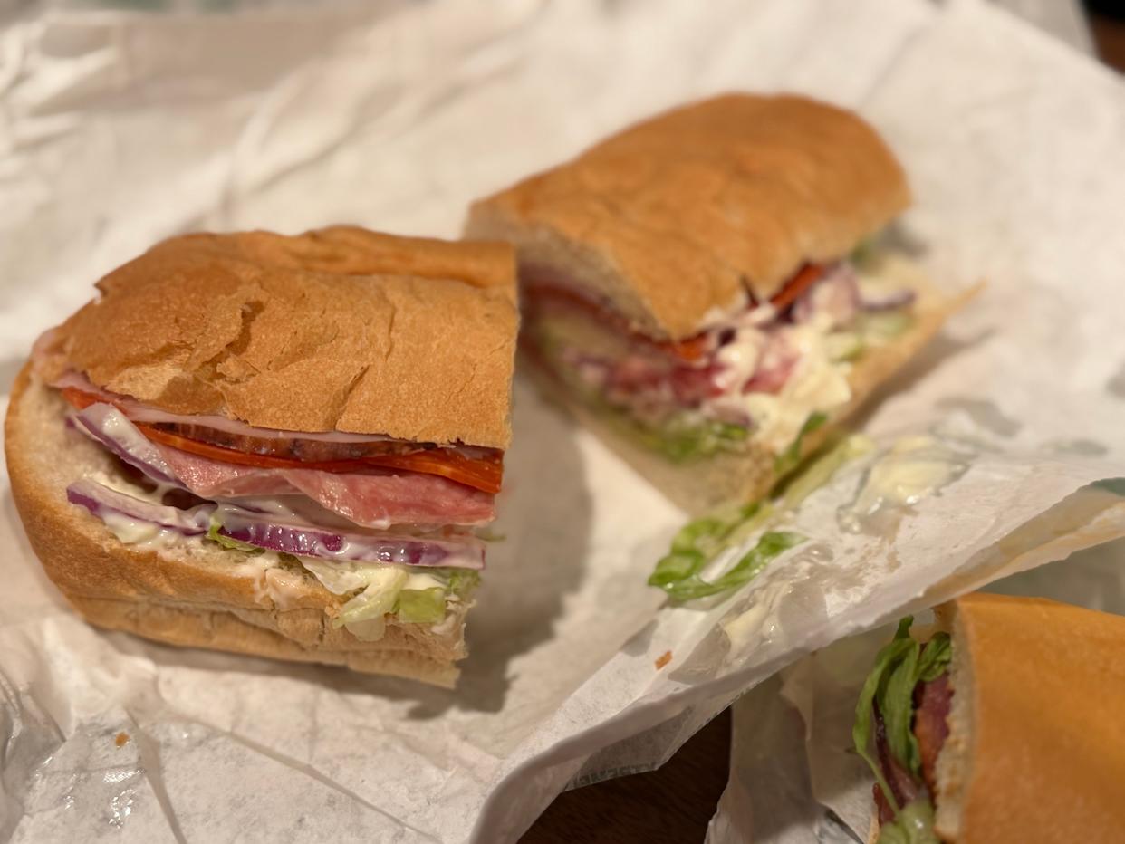 Subway ITalian sandwich cut in half on paper