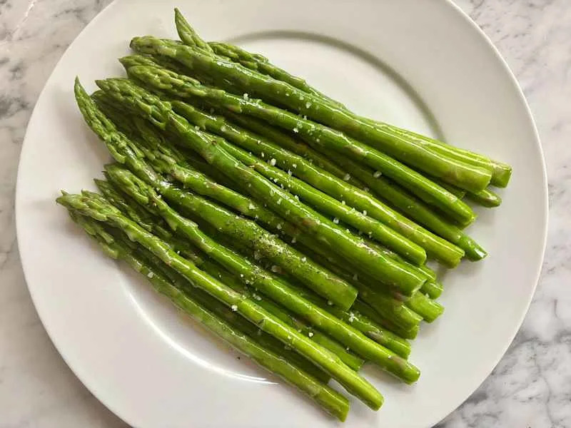 Salt and pepper sprinkled on asparagus.