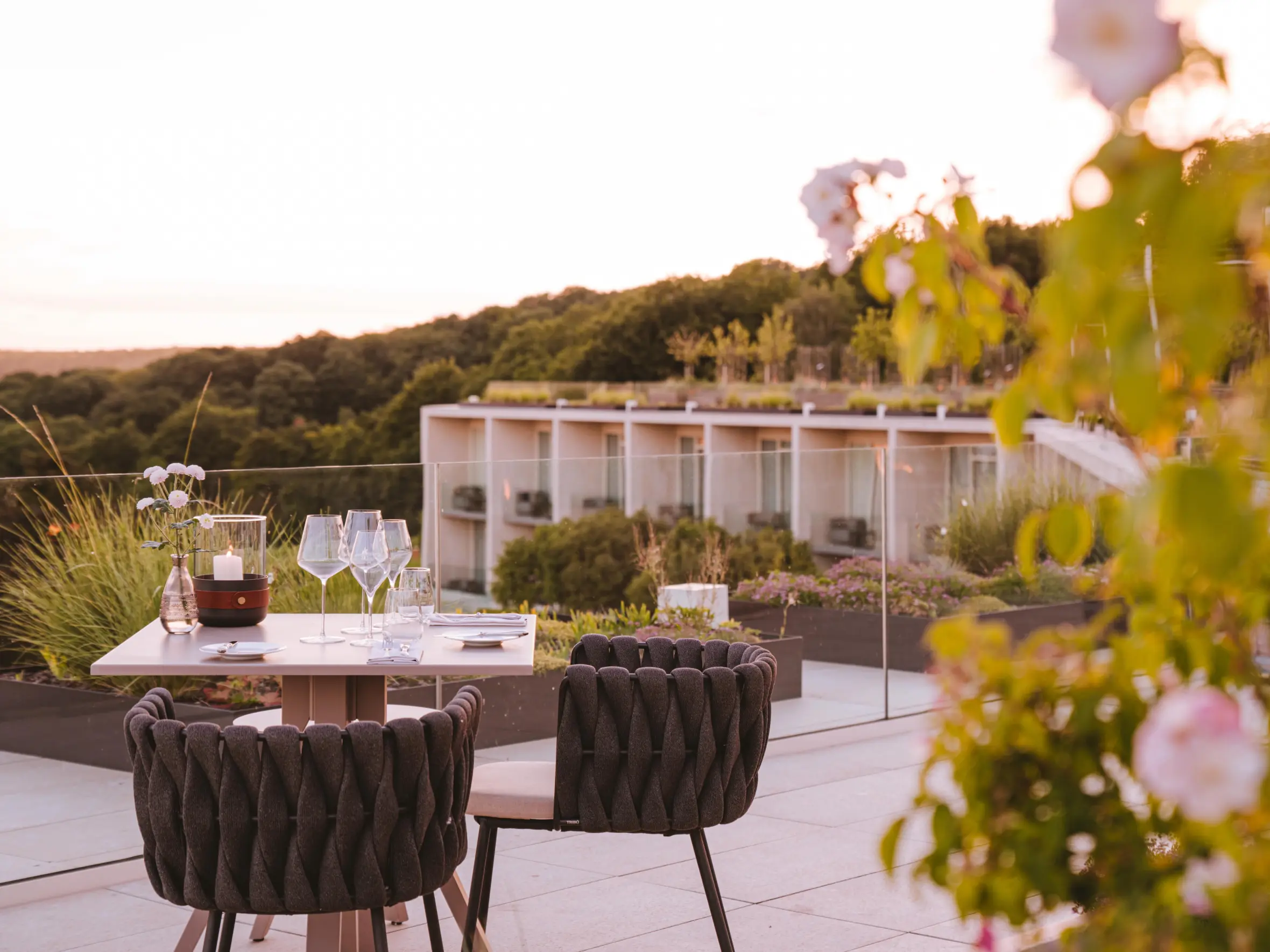 An outdoor dining table set for two with a panoramic view of the Royal Champagne Hotel & Spa, Chatillon.