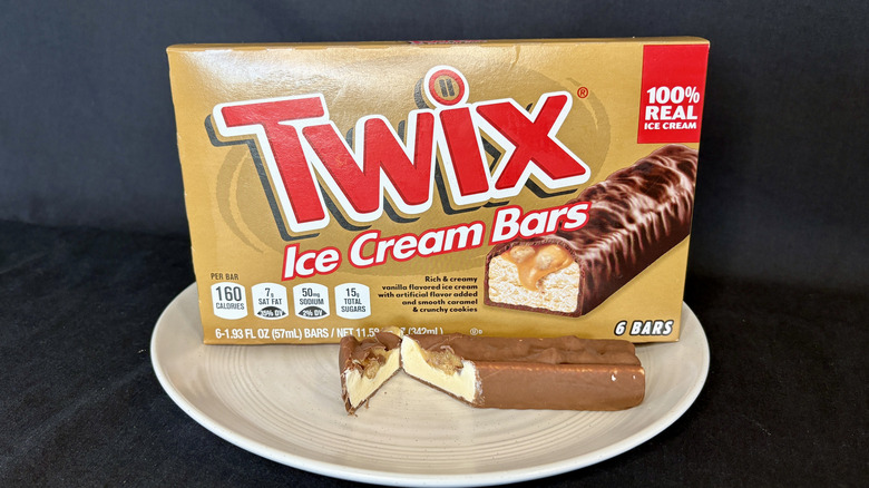 Twix ice cream bar cut open on plate with box in background