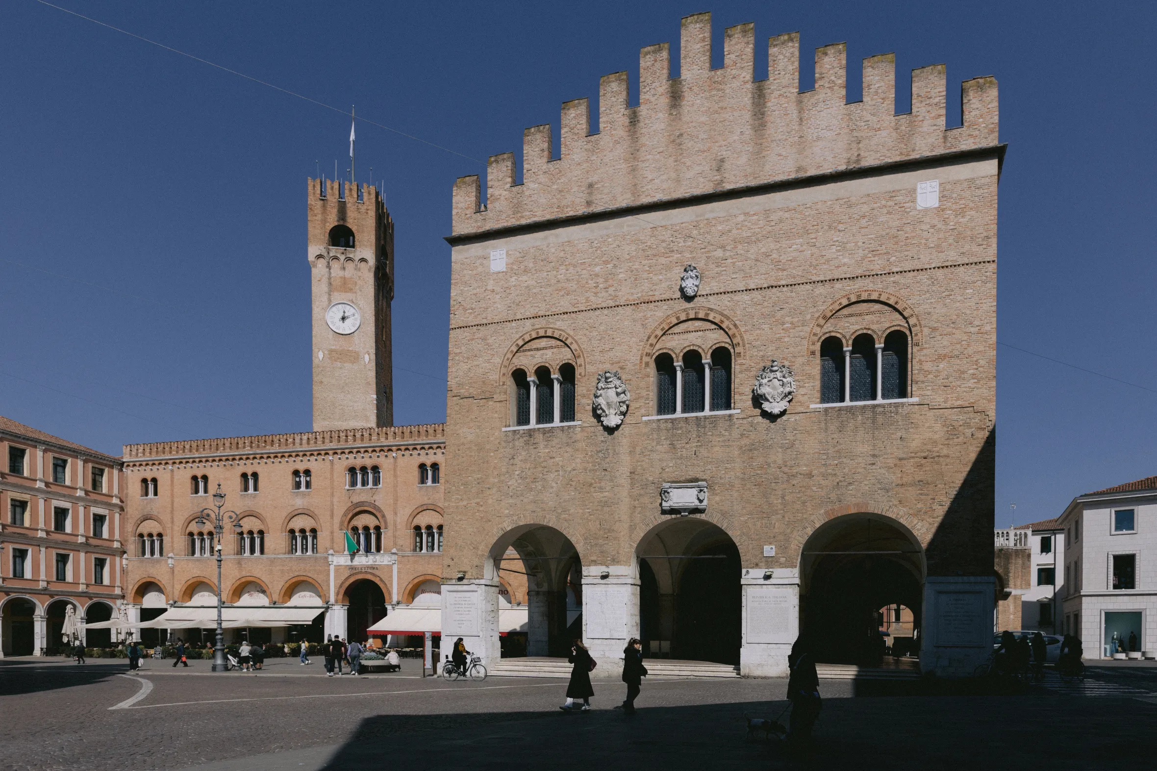 Piazza dei Signori in Treviso, Italy, with a clock tower and arcaded buildings.