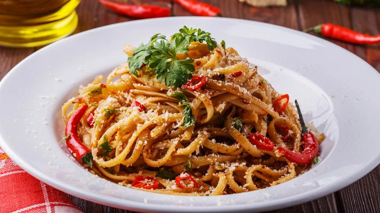 Pasta all'arrabbiata with red chili pieces and chiles in a round dish