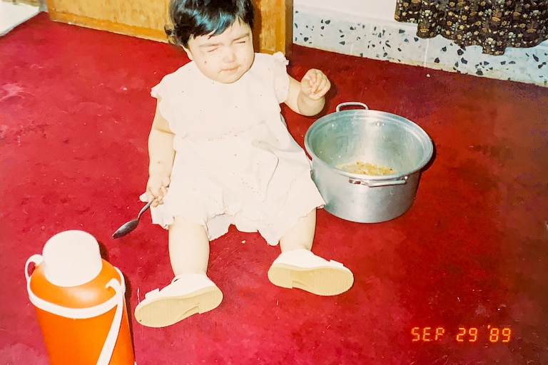 Iman Sediqe as a baby helping cook with relative in Kuwait in 1989.