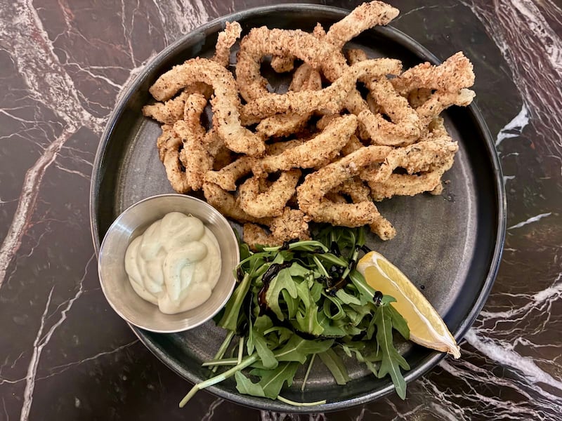 Plate of calamari with aioli and rocket leaves