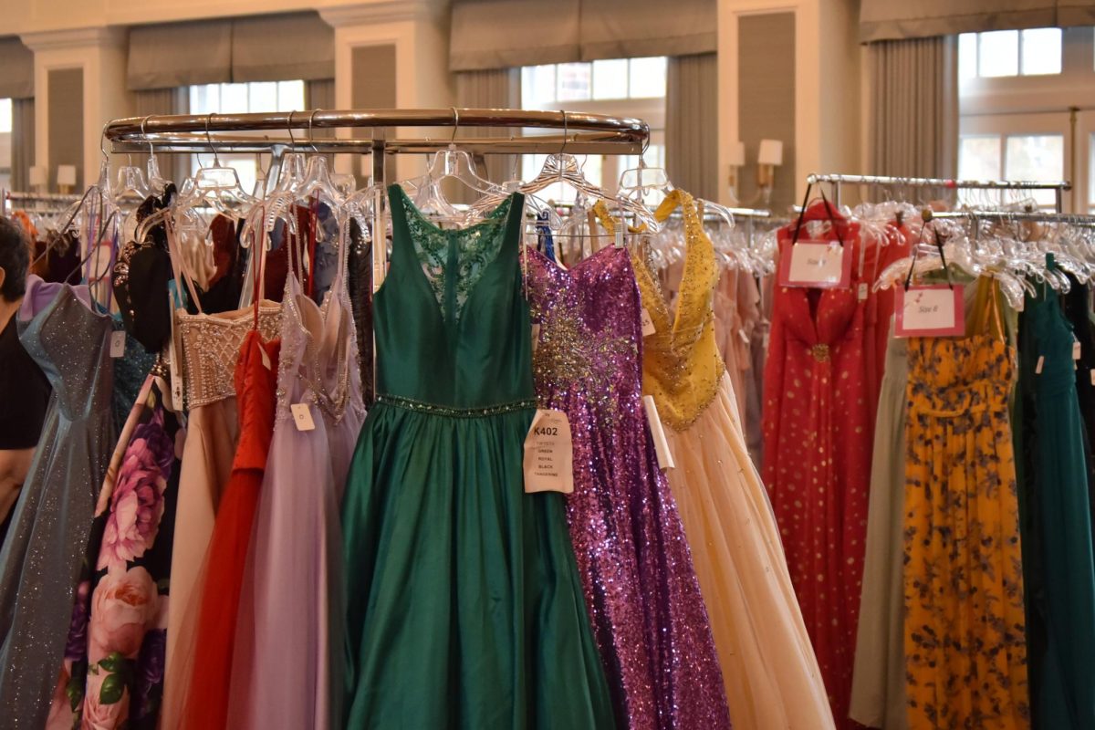Prom dresses hang on a rack. 
