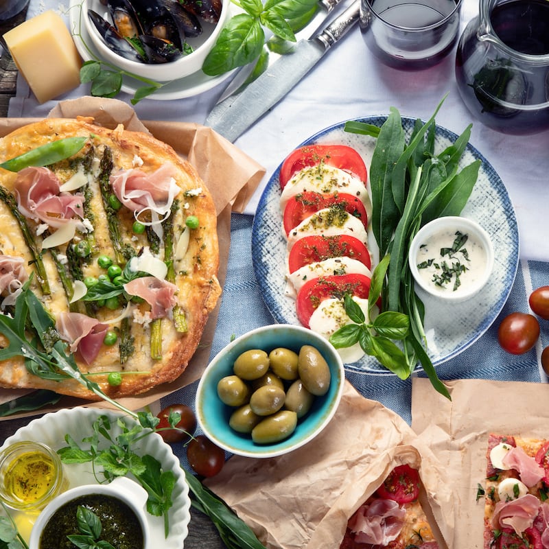 Appetizing classic Italian cuisine on rustic wooden table. Different types of pizza, pasta, snacks and capreze. Healthy homemade food. Top view, flat lay