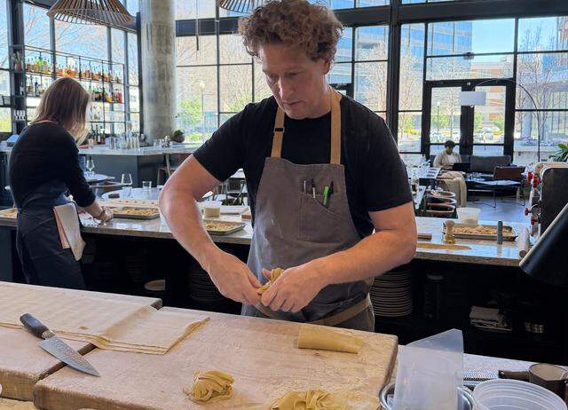 A chef is twisting long, flat ribbons of Tagliatelle or Pappardelle into into “nests.”