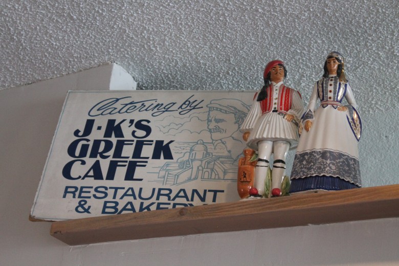A J-K's Greek cafe sign and ceramic figurines