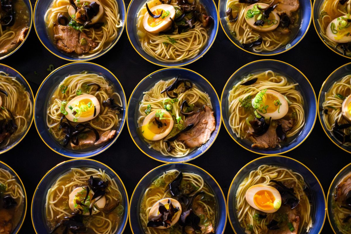 Bowls of noodles on a black background.