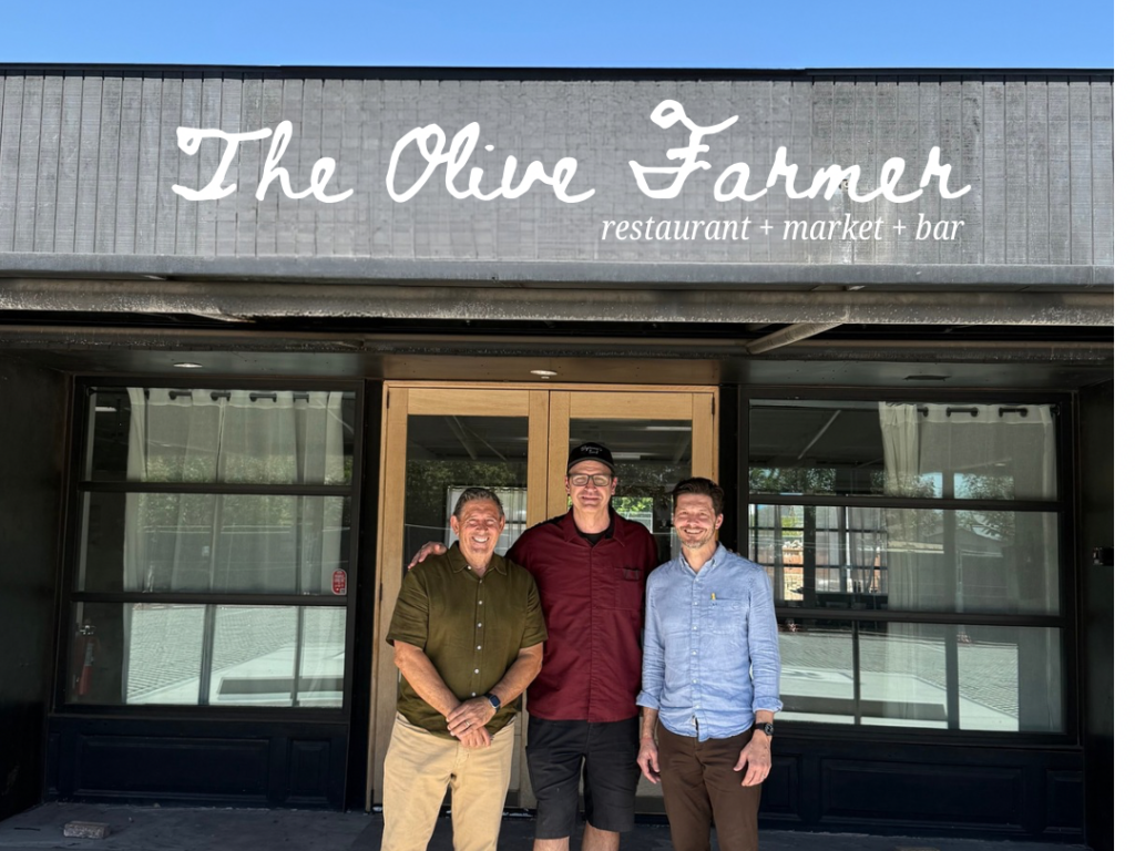 Three owners of a new restaurant, market and bar standing outside.