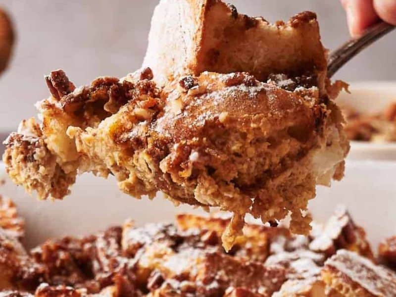 A person taking a portion of French toast casserole.