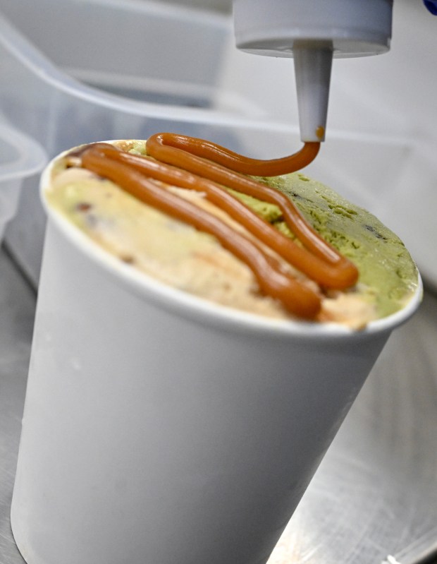 Adam Yala puts the finishing touches on a pint of Turtle Frownie at Sadboy Creamery in Denver on Tuesday, April 14, 2026. (Photo by AAron Ontiveroz/The Denver Post)