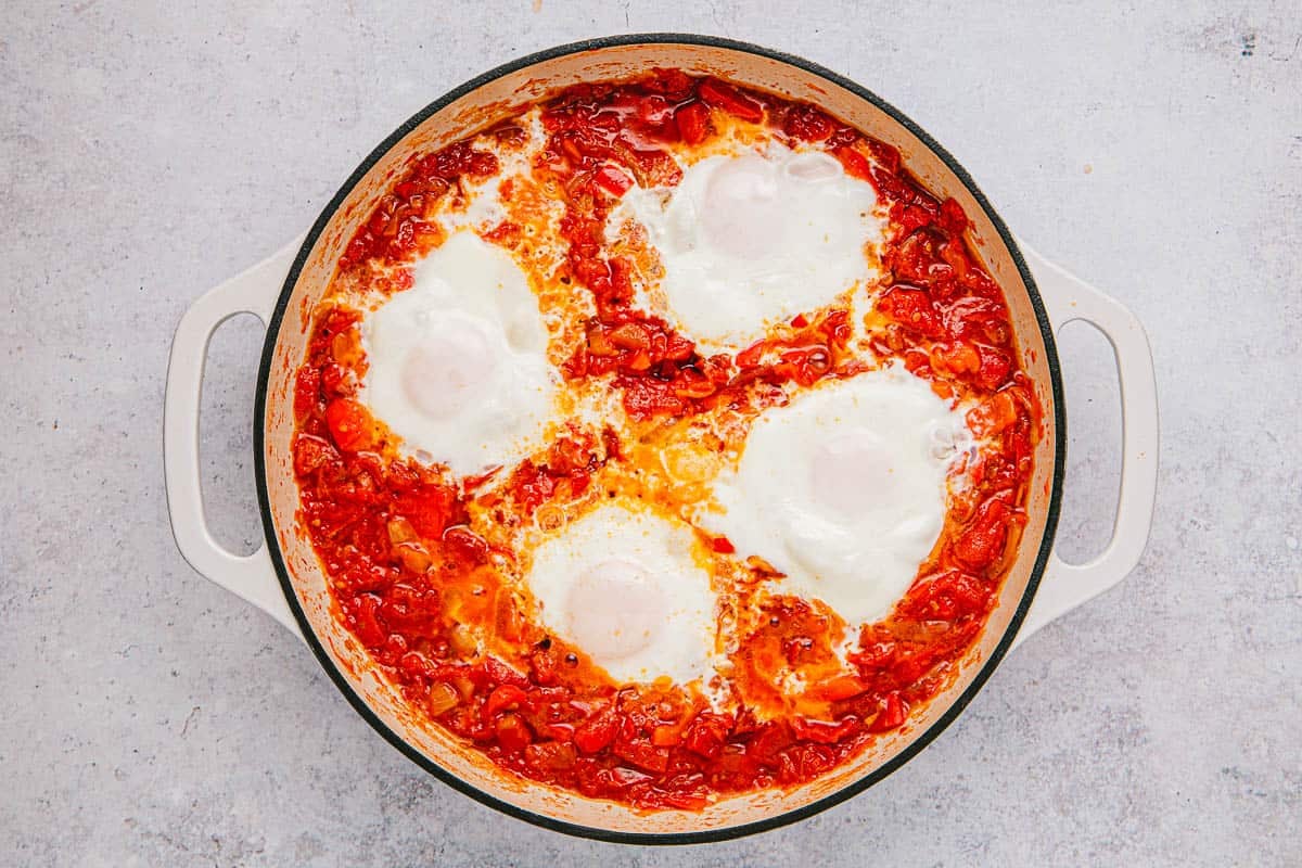 eggs in purgatory cooking in a skillet.