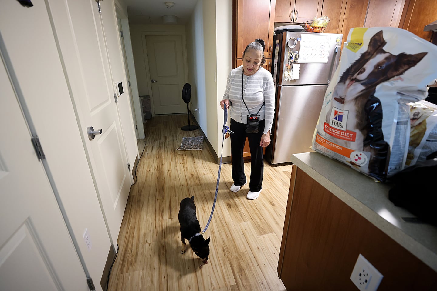 YmaNini LaCourt stands in her apartment with her dog Mizzo.