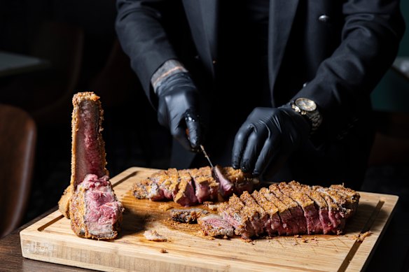 The crumbed T-bone steak is carved tableside.