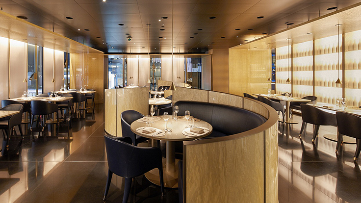 The interior features wave-shaped sofa seating set against a calm gold palette. (© ARMANI / RISTORANTE) 