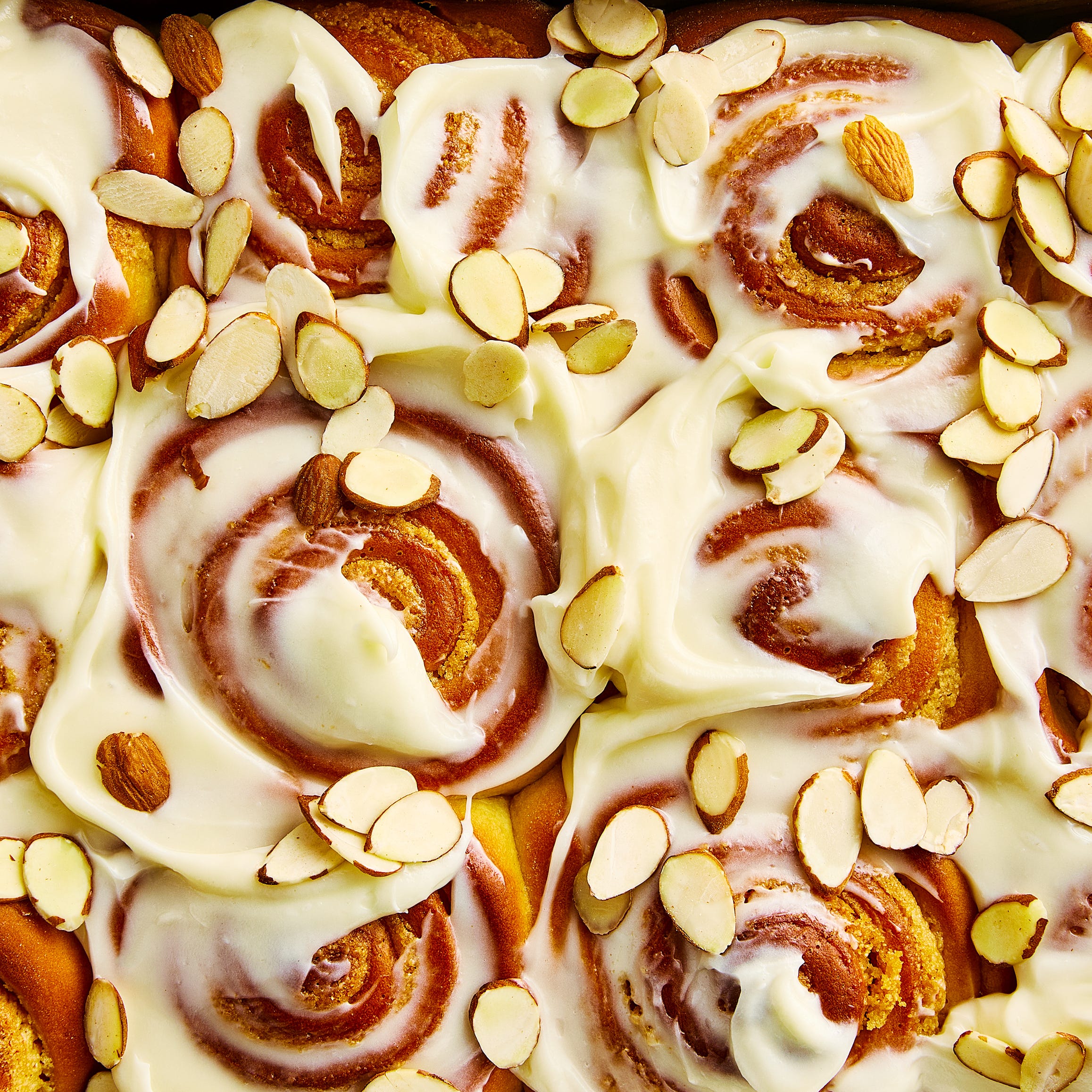 cinnamon rolls with cream cheese icing and sliced almonds