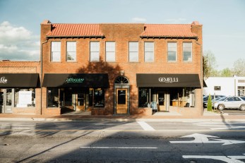 Brick storefront building with two black awnings for Gemelli Italian and Affogato Gelato & Espresso on a sunny street scene.