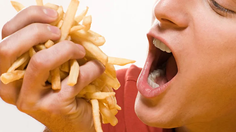 Man with handful of fries