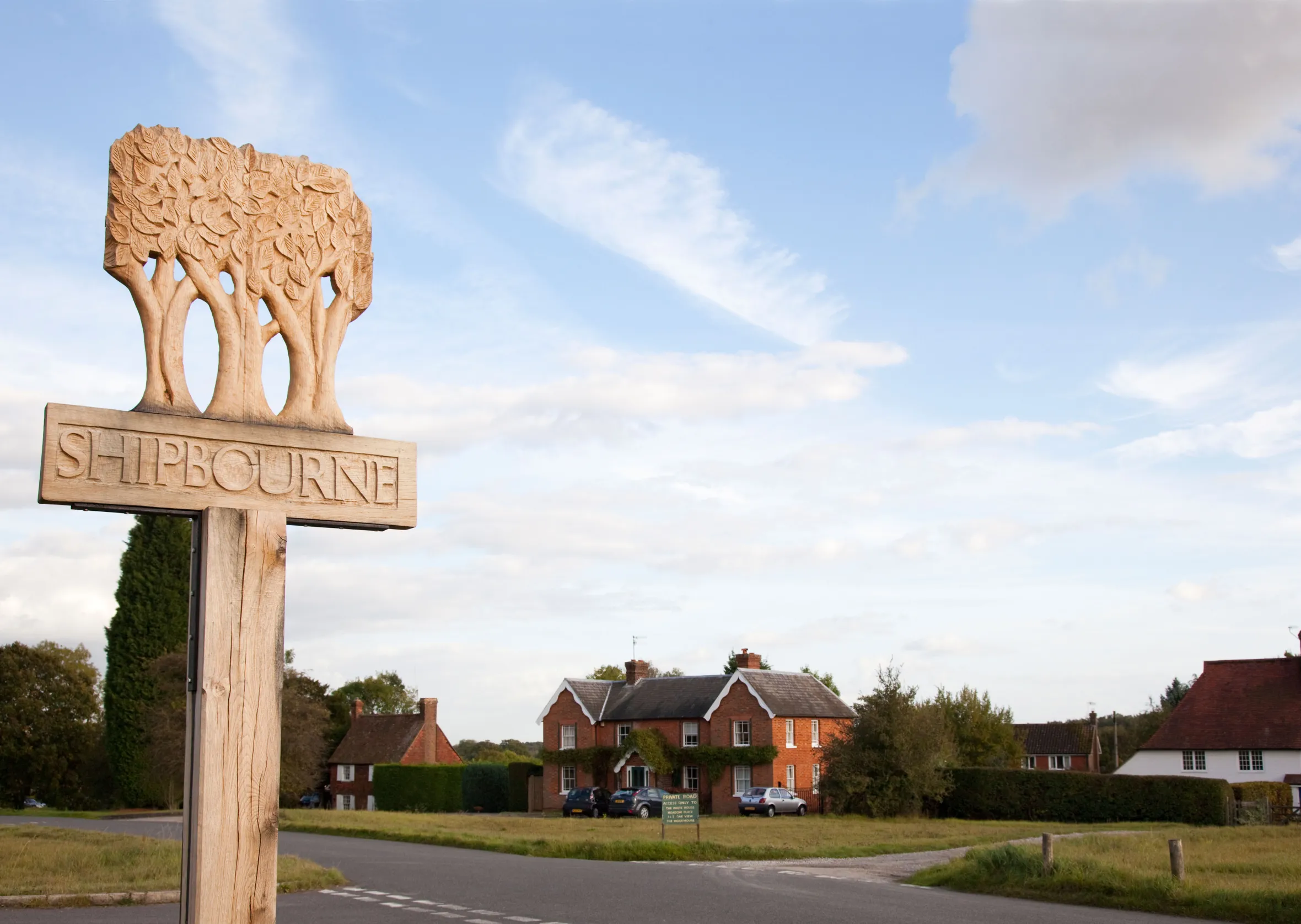 Village sign for Shipbourne, Kent, UK, carved with a tree motif.
