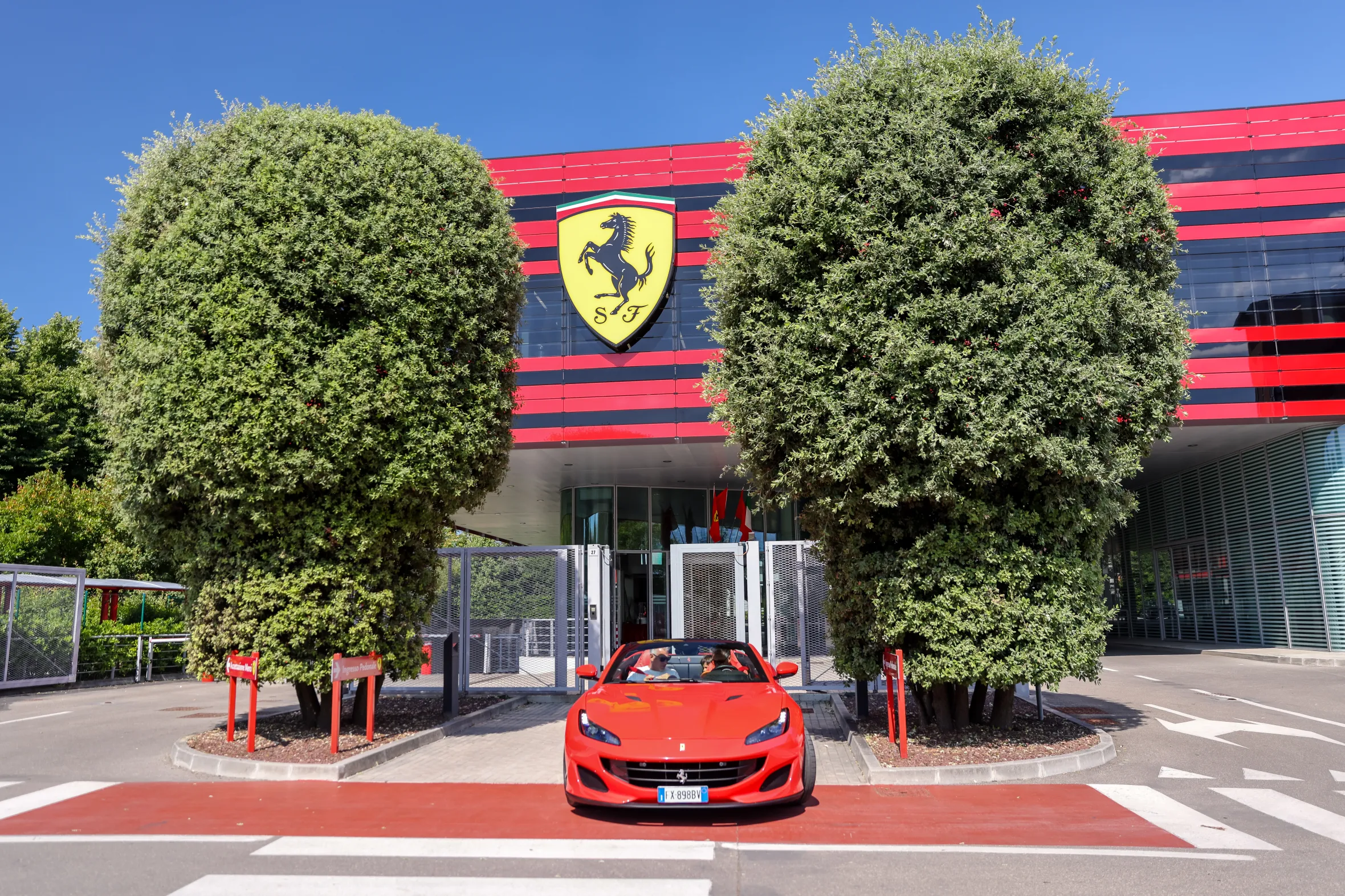 Ferrari Museum exterior with a red sports car parked in front.