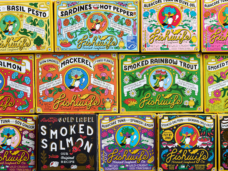 Colorful assortment of Fishwife canned seafood products, including smoked salmon, mackerel, and sardines.