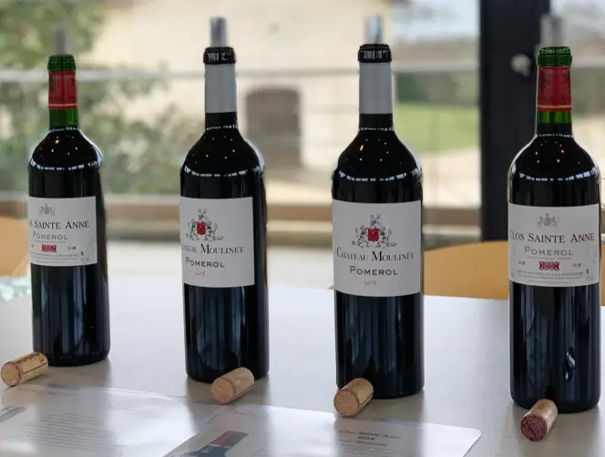 Château Moulinet wine bottles on a table with corks.