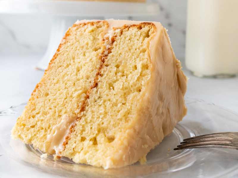 Slice of sour cream cake on plate.