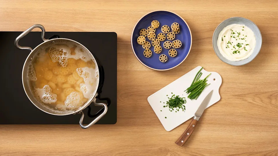 Racing tire shaped pasta in pot of boiling water alongside the dried pasta on a plate