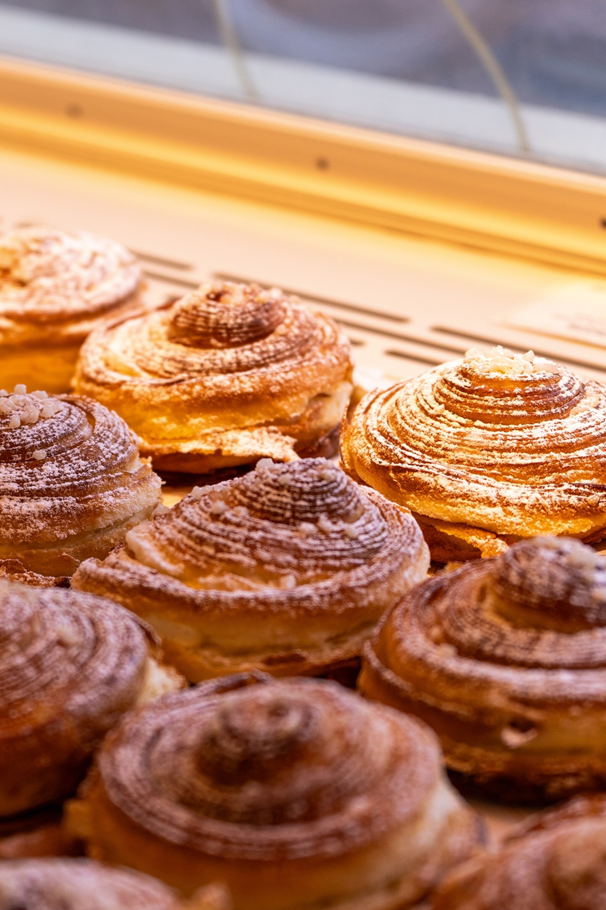 A close-up of rolled brioche pastry in a window display.