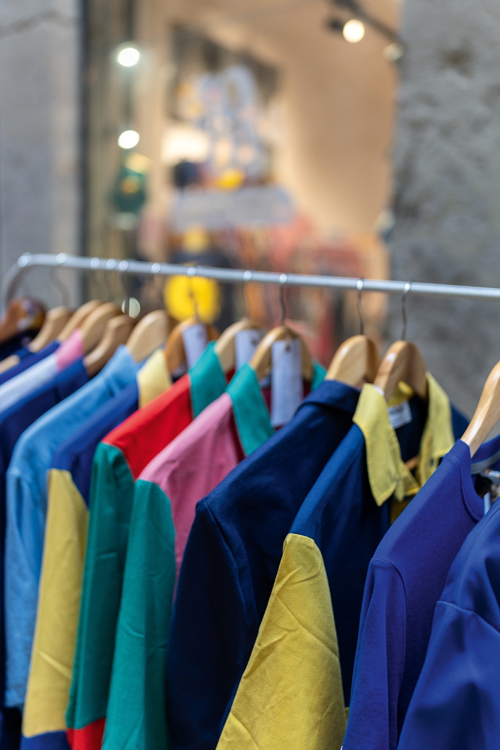 A row of second-hand shirts on a rack.
