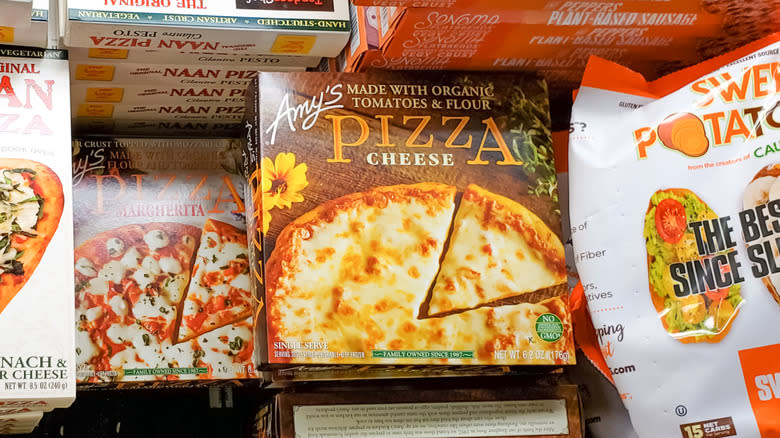 Two varieties of Amy's Pizza sit in a grocery store cold case