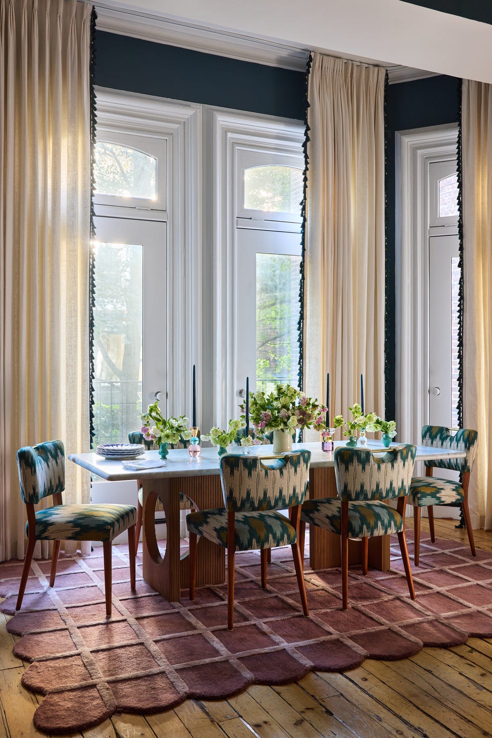 Dining area featuring a table with floral arrangements and patterned chairs.