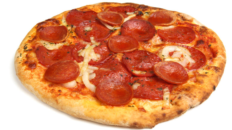 Uncut pepperoni pizza on white background