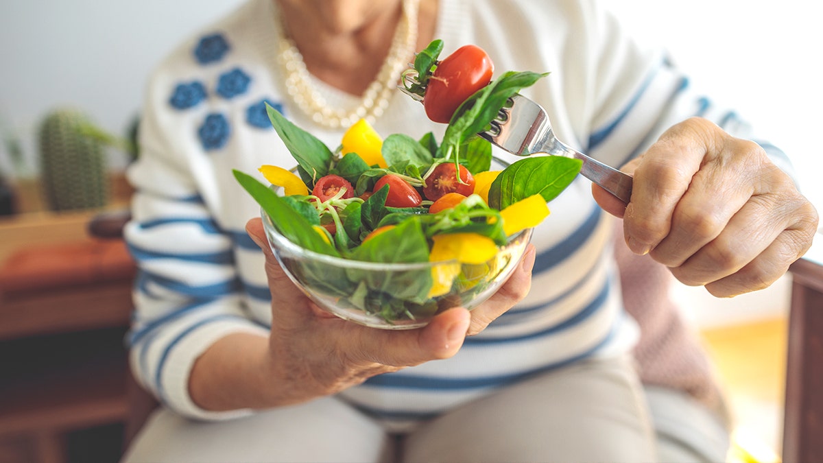 Woman eating a salad with vegetables
