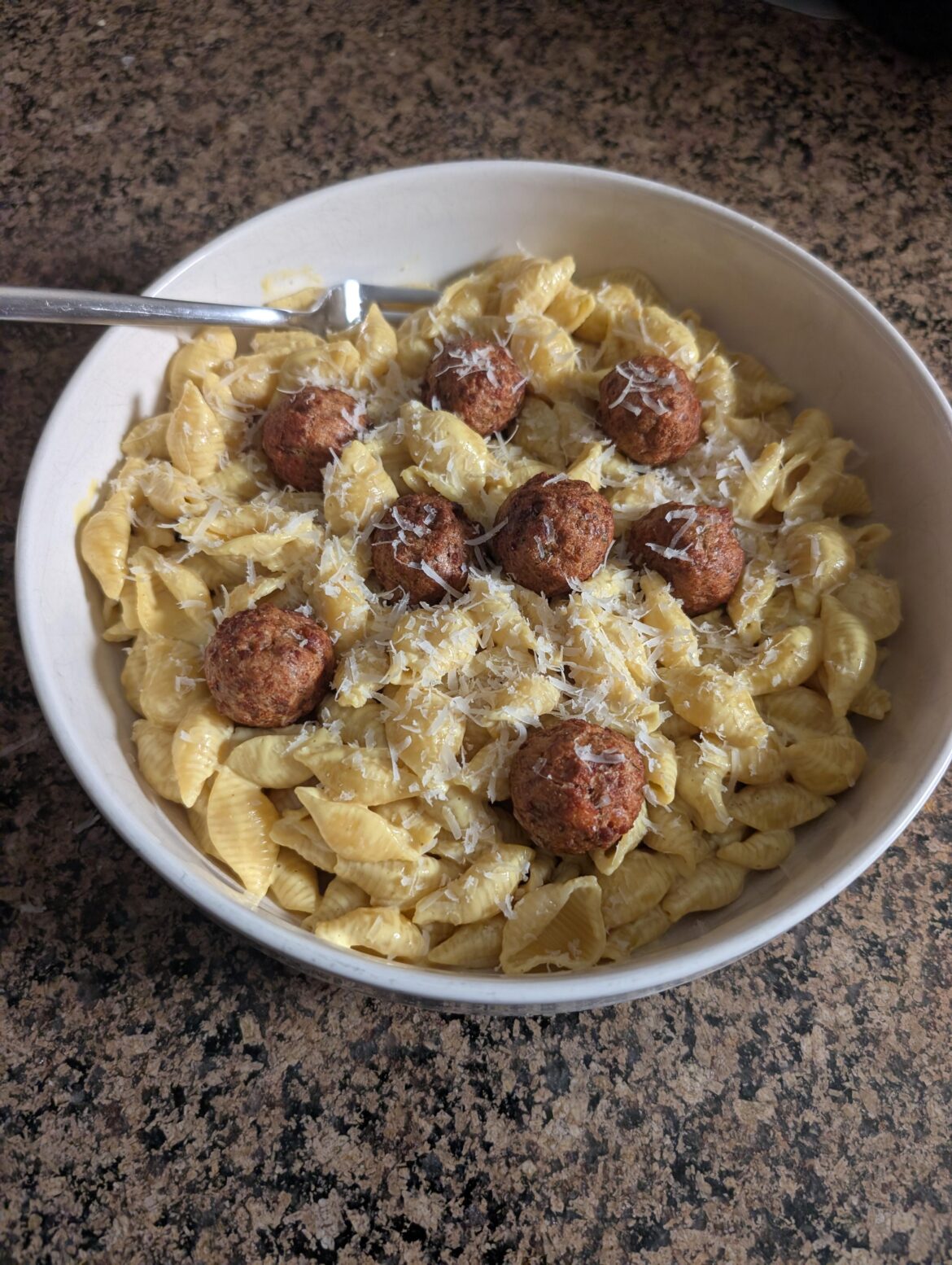 Nut-Free Vegan Mac and Cheese with some vegan meatballs and vegan Parmesan on top.