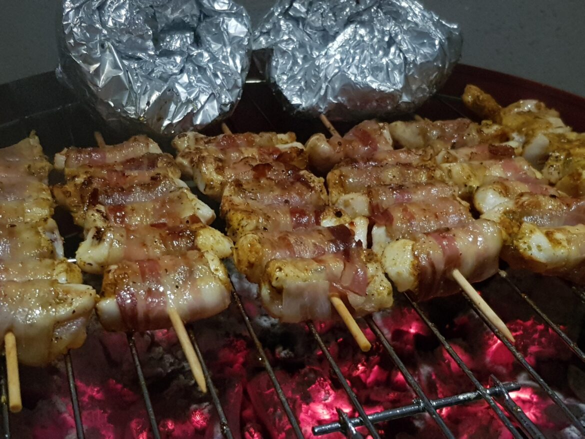 Bacon-wrapped chicken skewers on the grill