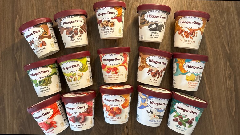17 different pints of Häagen-Dazs ice cream lying flat on a wood table