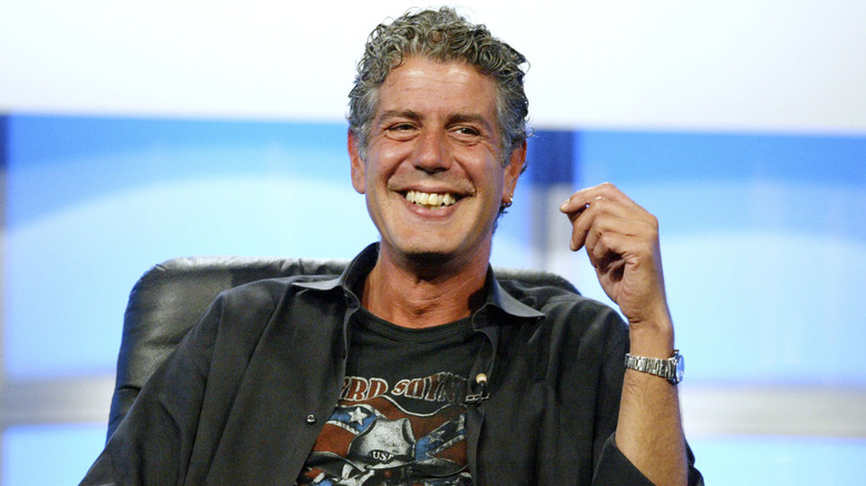 Anthony Bourdain grinning in a chair.