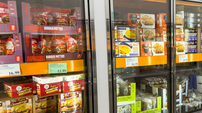 Freezers at Costco store displaying products including burger patties and breakfast sandwiches