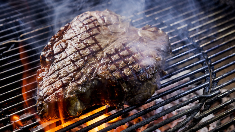 A t-bone steak on a hot grill