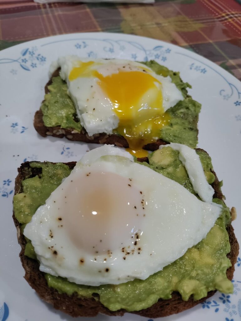 Middle age millennial Classic, avocado toast with runny eggs for Saturday morning breakfast.