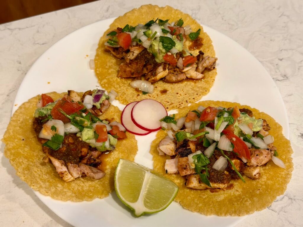 Pollo Asado tacos with salsa roja, guacamole, and pico de gallo