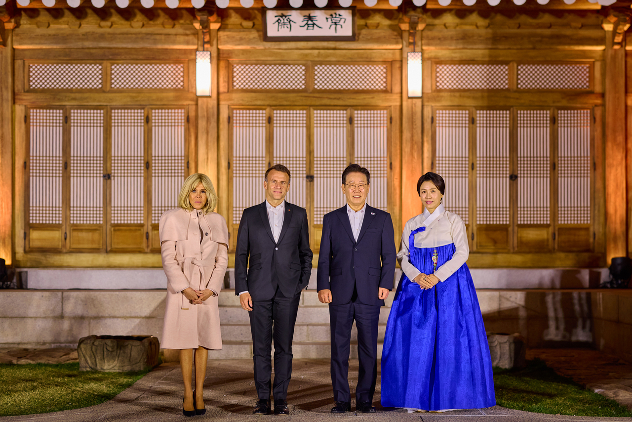 Brigitte Macron (far left), French President Emmanuel Macron (center left), President Lee Jae Myung (center right) and first lady Kim Hea Kyung (far right) pose for a photo during the state banquet at Sangchunjae in Cheong Wa Dae in Seoul on Thursday. (Cheong Wa Dae via Yonhap)