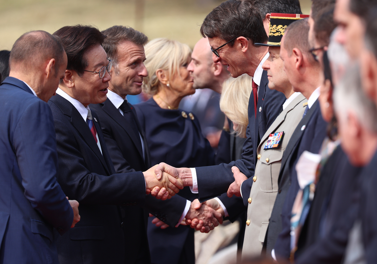 President Lee Jae Myung greets members of the French delegation during the official welcoming ceremony for French President Emmanuel Macron at Cheong Wa Dae in Seoul on Friday. (Yonhap)