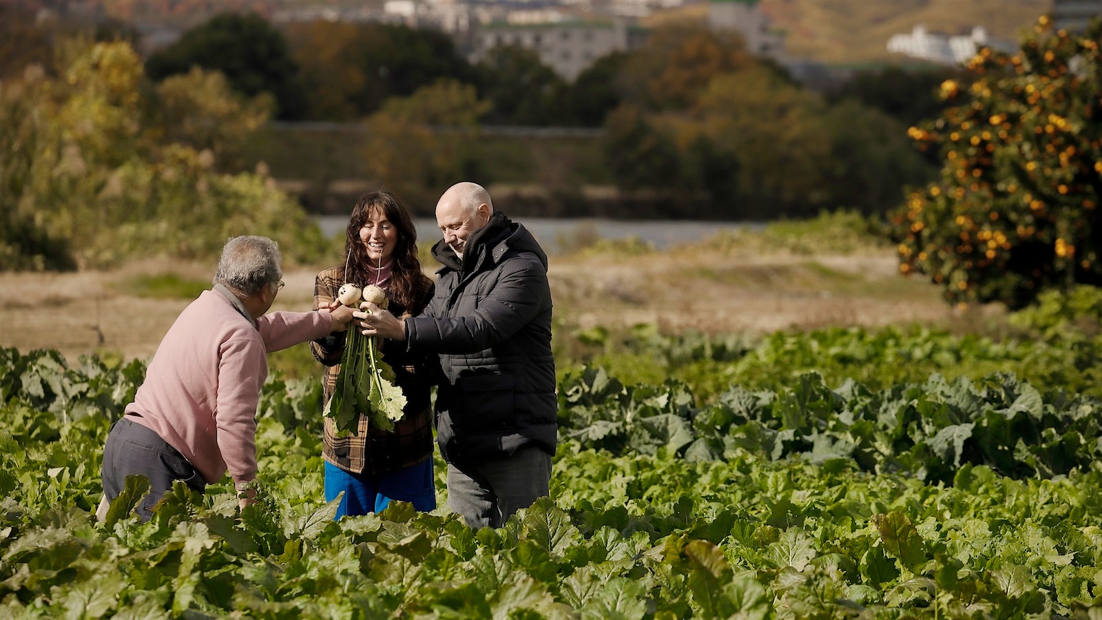 Kyle and Katina Connaughton in a field with a farmer in Japan.