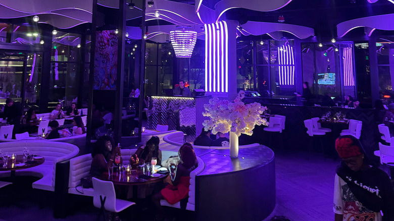 Interior of STK restaurant in Los Angeles with purple-colored lighting creating a dim interior