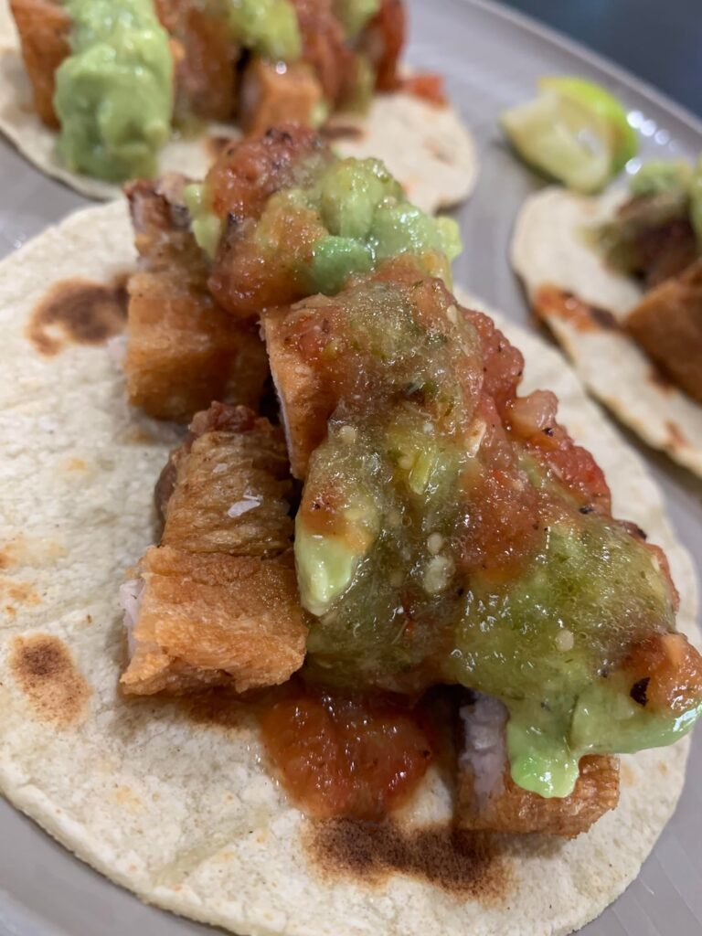 Pork belly chicharron tacos with homemade salsa tatemada, salsa verde, y guacamole
