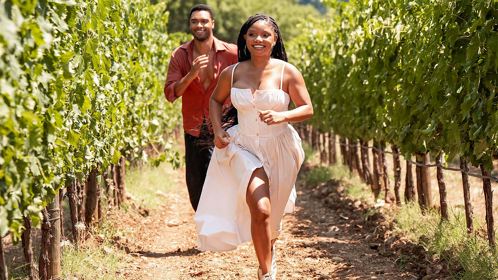 Regé-Jean Page and Halle Balley running in a vineyard in "You, Me, and Tuscany” from Universal Pictures.